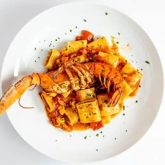 Pasta with lobster on white plate